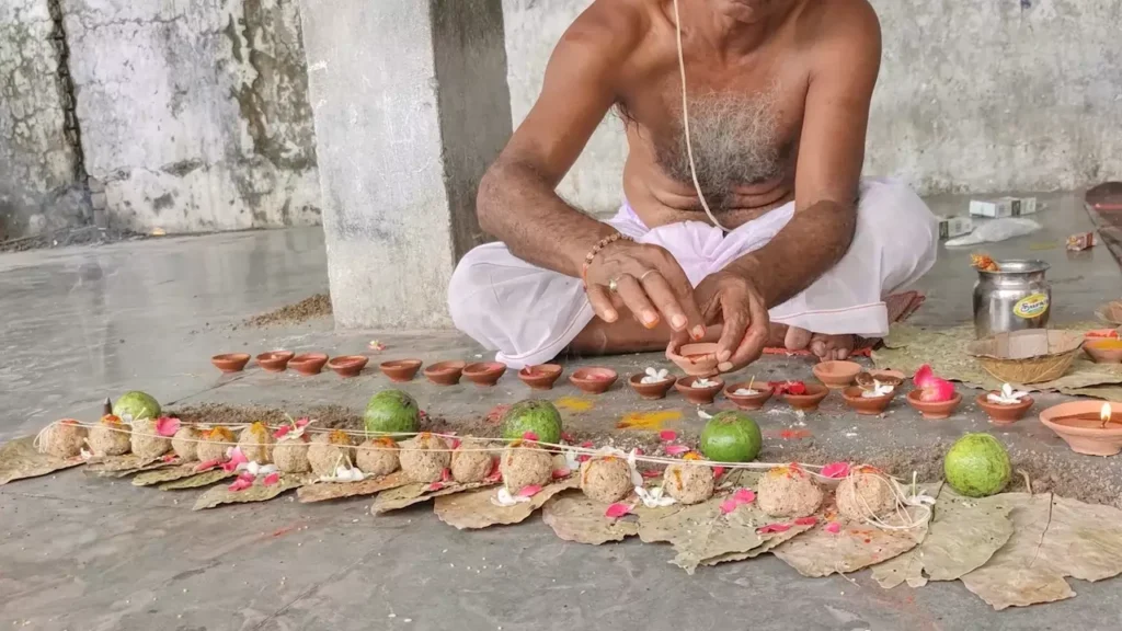A priest performs the Pind Daan ritual, carefully arranging rice balls (pindas) and other offerings for his ancestors- Home Shradh timing Muhurat Tithi